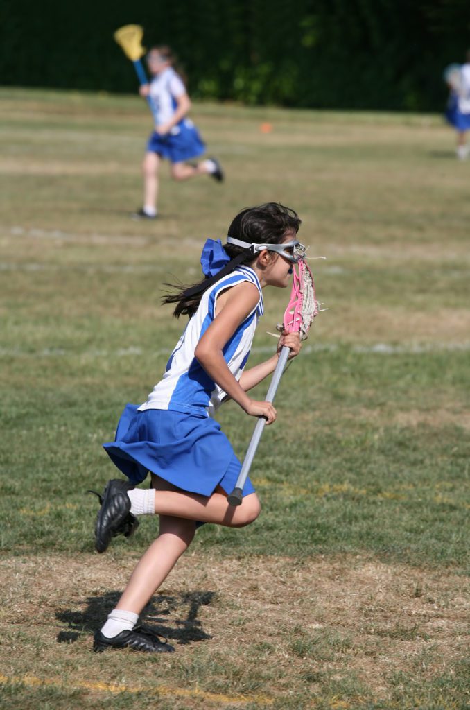 a girl performing lacrosse training